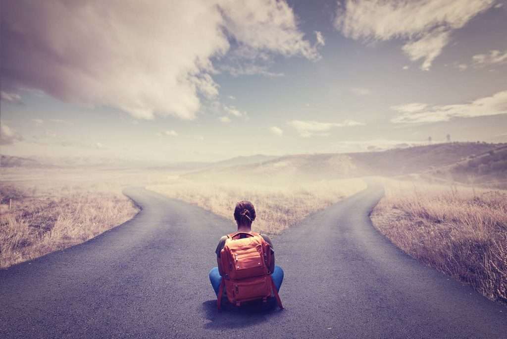 A woman on crossroads amidst fields